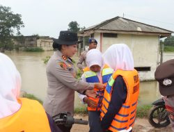Polres Lampung Timur Siagakan Personel Bantu Penyebrangan Warga dan Anak Sekolah di Sungai Way Bungur